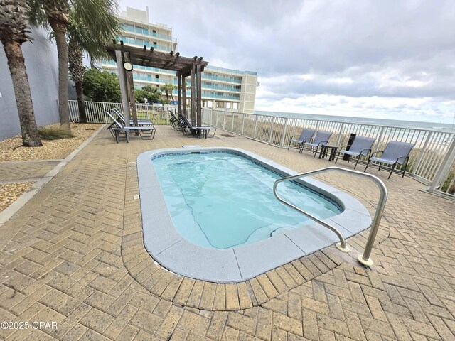 view of pool with a pool, a patio, and a water view