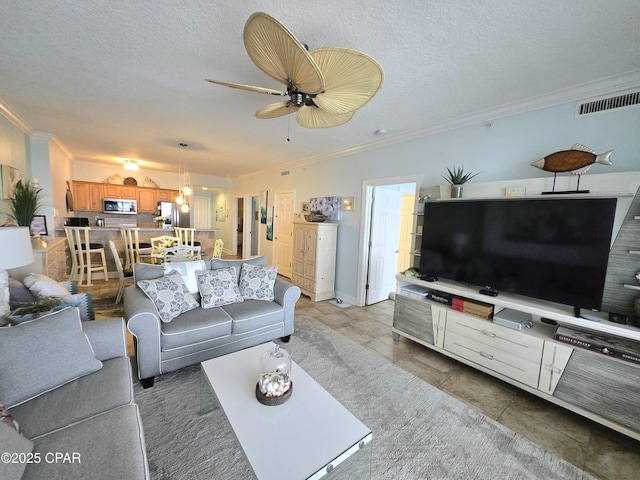 living room with visible vents, a textured ceiling, a ceiling fan, and ornamental molding