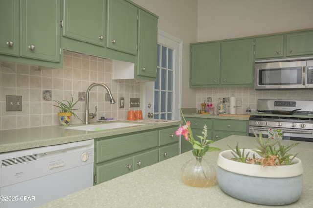 kitchen featuring green cabinets, appliances with stainless steel finishes, and a sink