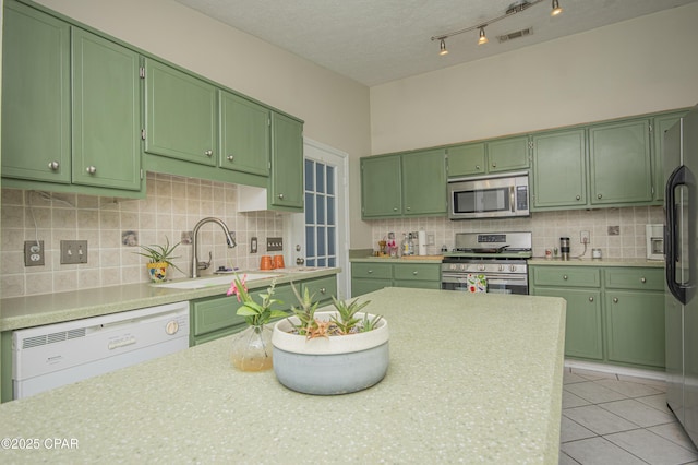 kitchen featuring a sink, light countertops, green cabinetry, and stainless steel appliances