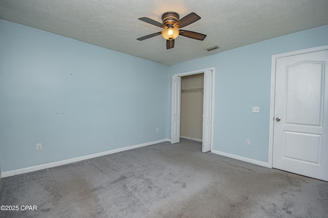 unfurnished bedroom featuring carpet flooring, baseboards, visible vents, and a textured ceiling