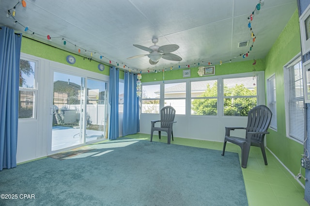 unfurnished sunroom with rail lighting, a ceiling fan, and visible vents