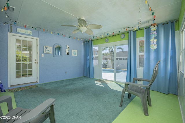 sunroom / solarium featuring track lighting and a ceiling fan