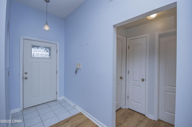 foyer entrance featuring light tile patterned flooring and baseboards