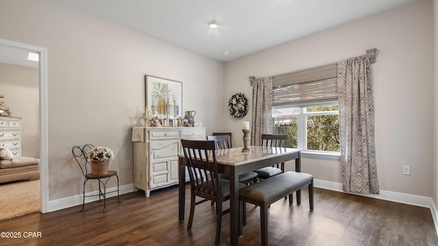 dining space with baseboards and dark wood-style flooring