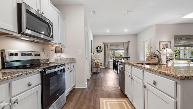 kitchen with visible vents, a wealth of natural light, appliances with stainless steel finishes, and dark wood-style flooring