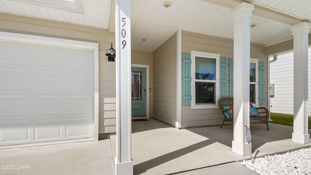 view of exterior entry with an attached garage and covered porch