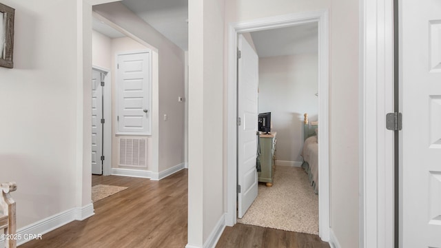 corridor featuring baseboards, visible vents, and dark wood-style floors