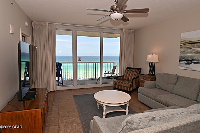 10811 Front Bch Unit 501, Panama City Beach, FL 32407 - living room with a ceiling fan, tile patterned flooring, and a textured ceiling