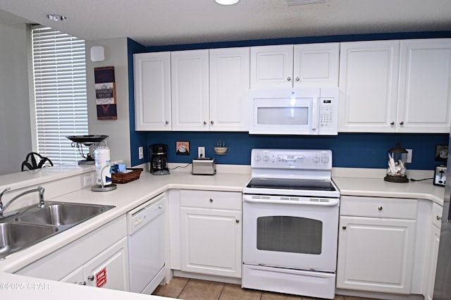 10811 Front Bch Unit 501, Panama City Beach, FL 32407 - kitchen featuring white appliances, white cabinets, light countertops, and light tile patterned floors