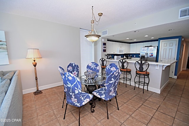 10811 Front Bch Unit 501, Panama City Beach, FL 32407 - dining area featuring light tile patterned floors, recessed lighting, and a textured ceiling