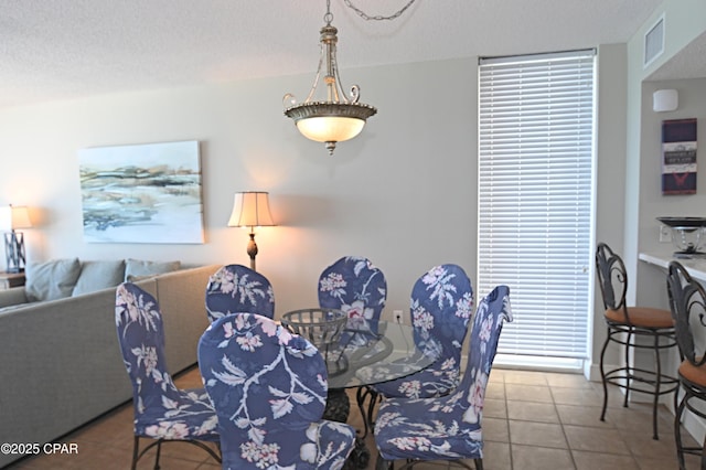 10811 Front Bch Unit 501, Panama City Beach, FL 32407 - dining area featuring tile patterned floors and a textured ceiling