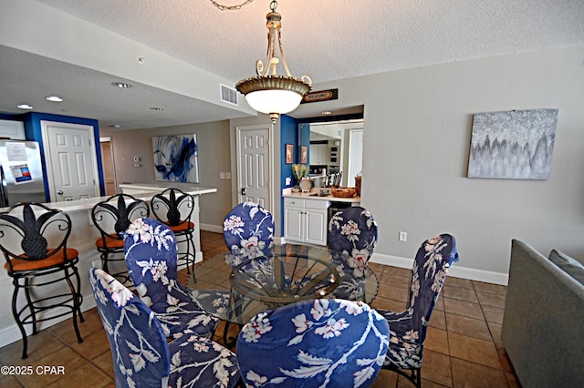 10811 Front Bch Unit 501, Panama City Beach, FL 32407 - dining area with a textured ceiling and tile patterned floors