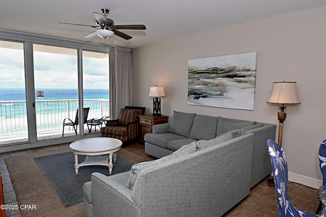 10811 Front Bch Unit 501, Panama City Beach, FL 32407 - living room with healthy amount of natural light, ceiling fan, tile patterned flooring, and a water view