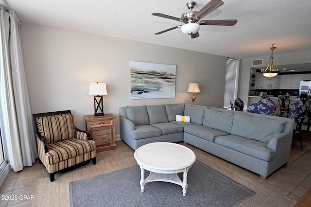 10811 Front Bch Unit 501, Panama City Beach, FL 32407 - living area featuring a ceiling fan, a textured ceiling, and light tile patterned floors