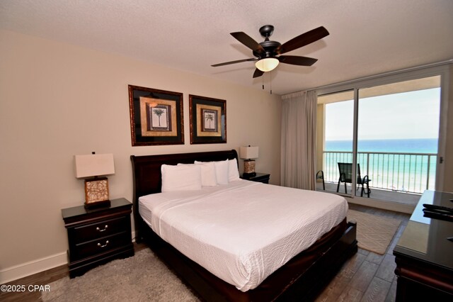 10811 Front Bch Unit 501, Panama City Beach, FL 32407 - bedroom featuring access to exterior, wood finished floors, a water view, expansive windows, and a ceiling fan