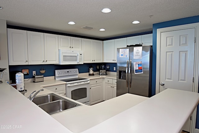10811 Front Bch Unit 501, Panama City Beach, FL 32407 - kitchen featuring white appliances, recessed lighting, white cabinetry, a textured ceiling, and light countertops