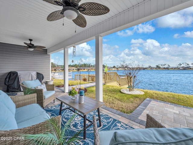 view of patio with an outdoor living space, a ceiling fan, and a water view