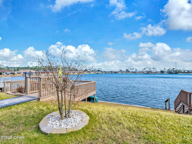 view of dock with a yard and a water view