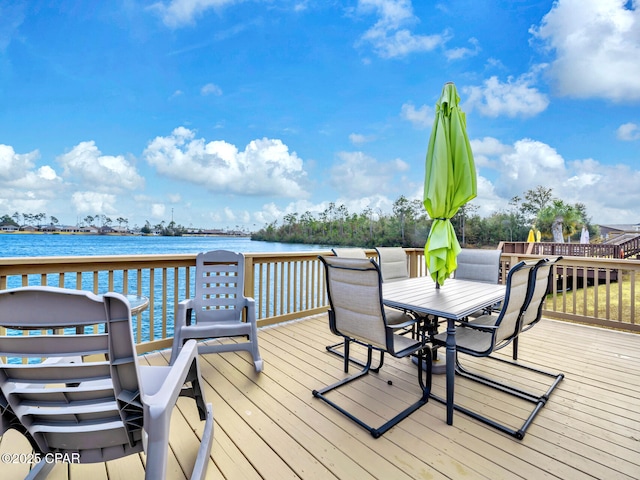 wooden terrace with outdoor dining area and a water view