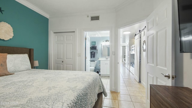 9450 S Thomas Unit 2106D, Panama City, FL 32408 - bedroom with ornamental molding, light tile patterned floors, a closet, and ensuite bath