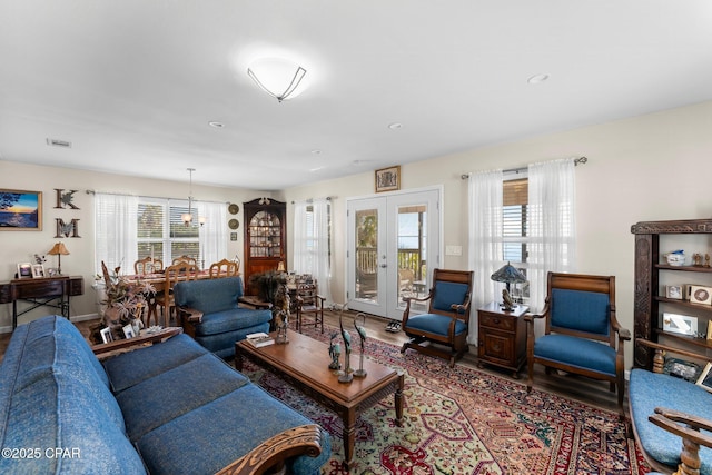 living area featuring visible vents, wood finished floors, and french doors