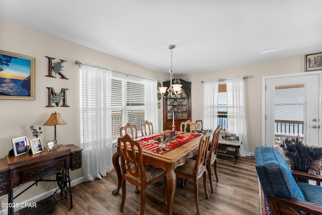 dining area with a notable chandelier, baseboards, and wood finished floors