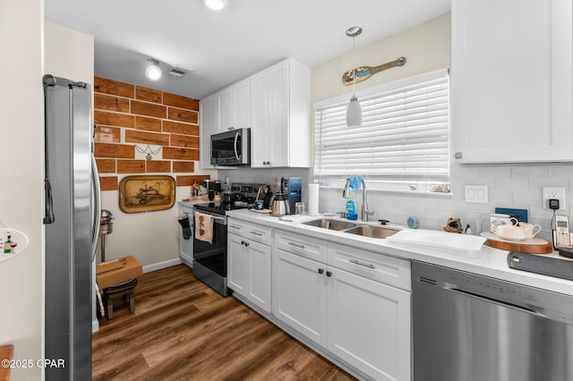 kitchen with decorative backsplash, white cabinetry, stainless steel appliances, and a sink