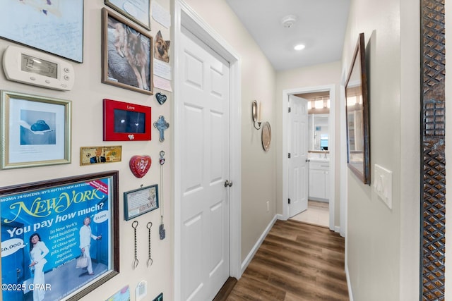 corridor featuring dark wood finished floors, recessed lighting, and baseboards