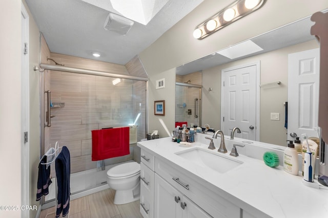 full bath with visible vents, a shower stall, vanity, and toilet