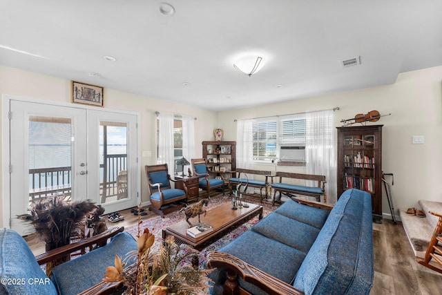 living room with french doors, baseboards, visible vents, and wood finished floors