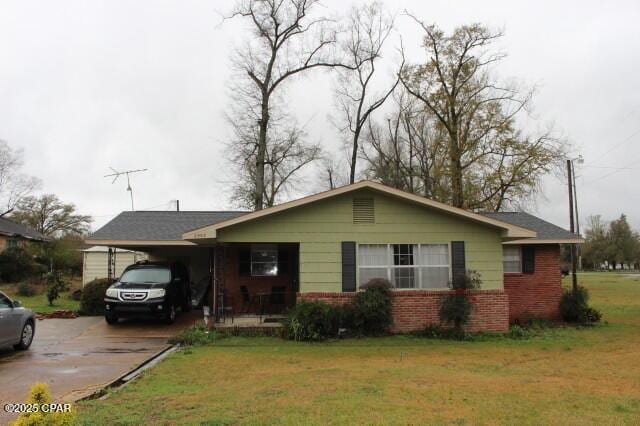 ranch-style house featuring a carport, a front lawn, concrete driveway, and brick siding