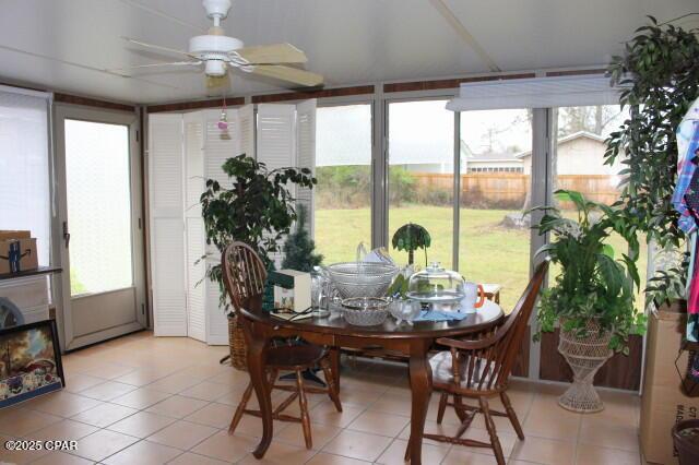 sunroom / solarium featuring ceiling fan