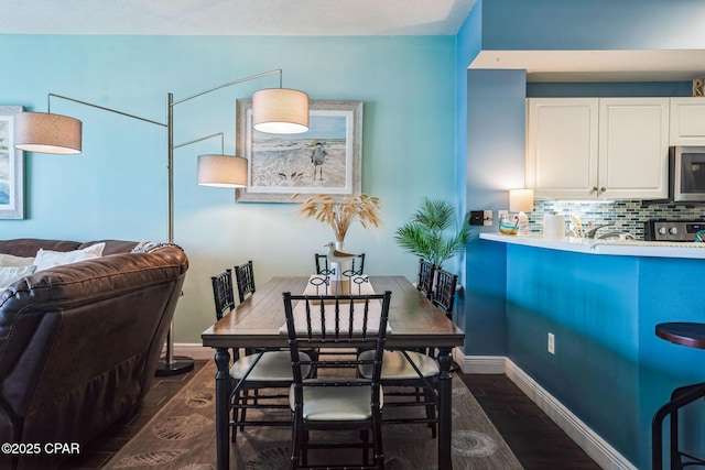 dining room with baseboards and dark wood-style flooring