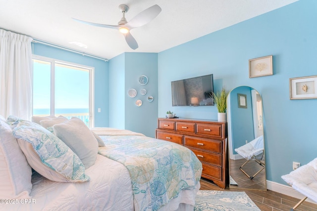 bedroom with ceiling fan, baseboards, arched walkways, and wood tiled floor