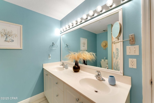 bathroom with double vanity, toilet, visible vents, and a sink