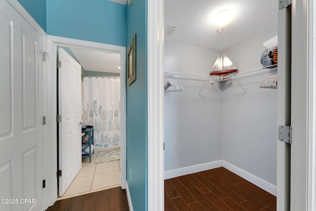 walk in closet featuring visible vents and wood finished floors