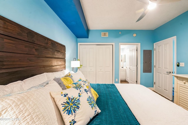 bedroom with visible vents, ensuite bath, electric panel, ceiling fan, and a closet