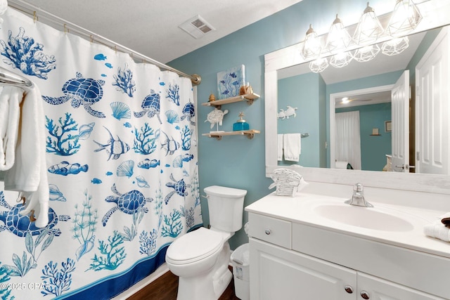 bathroom featuring visible vents, toilet, vanity, and a shower with shower curtain