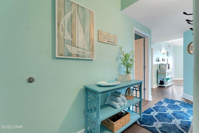 hallway featuring baseboards and wood finished floors