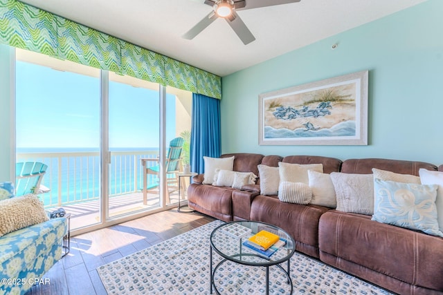 living room featuring a water view, ceiling fan, and wood finished floors