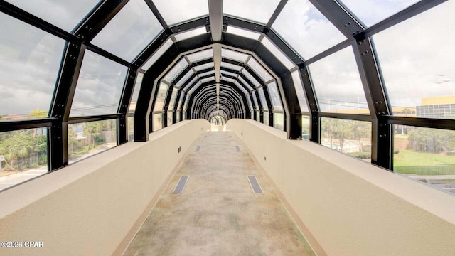 unfurnished sunroom featuring a wealth of natural light, visible vents, and lofted ceiling