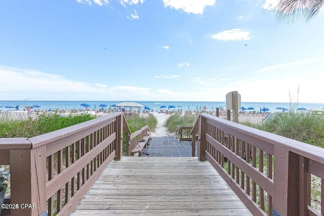 surrounding community featuring a deck with water view and a view of the beach