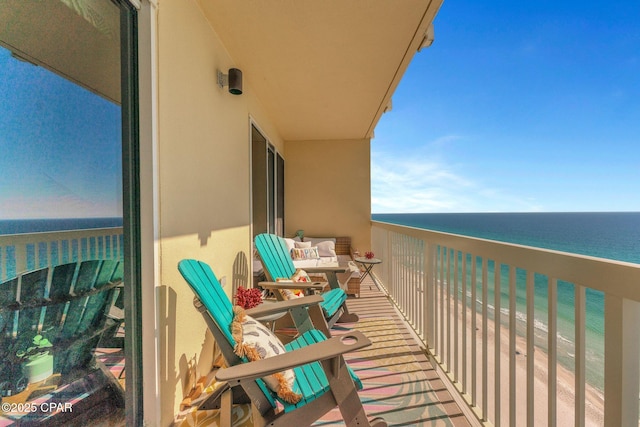 balcony featuring a beach view and a water view