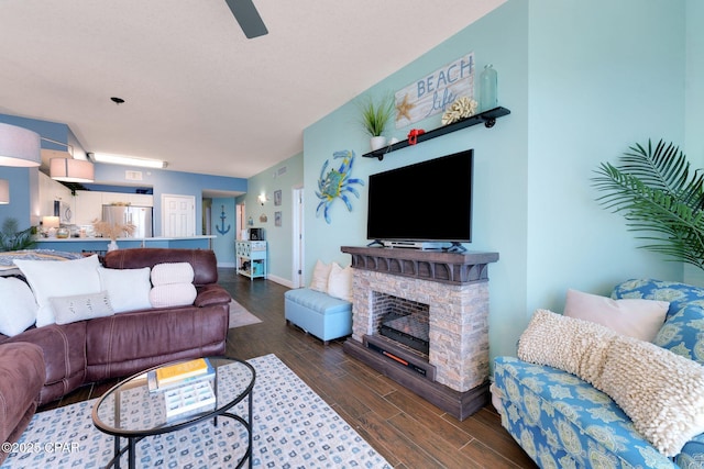 living room with baseboards, wood finished floors, and a fireplace