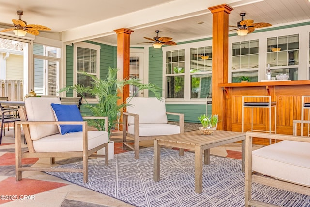 sunroom with a wealth of natural light, a ceiling fan, and decorative columns