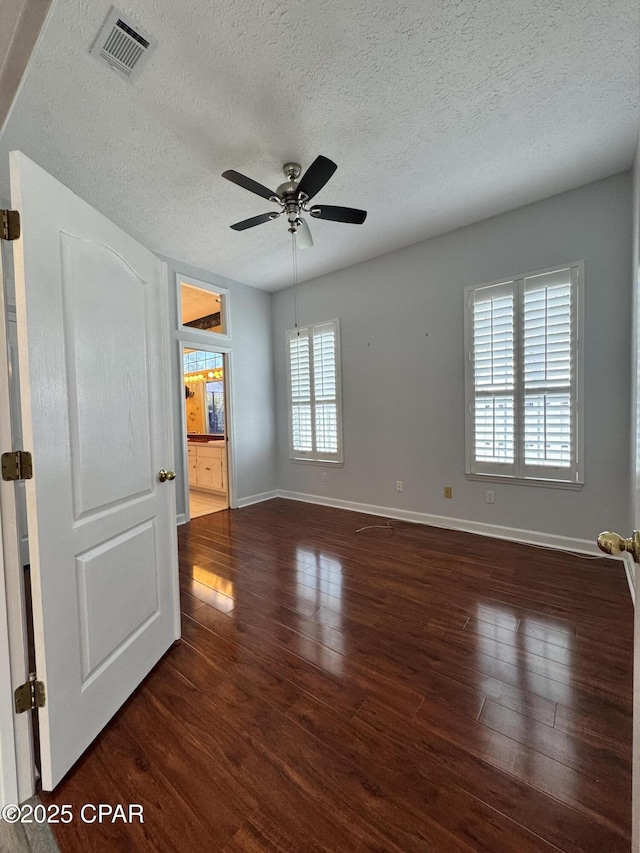 unfurnished room featuring visible vents, baseboards, and wood finished floors