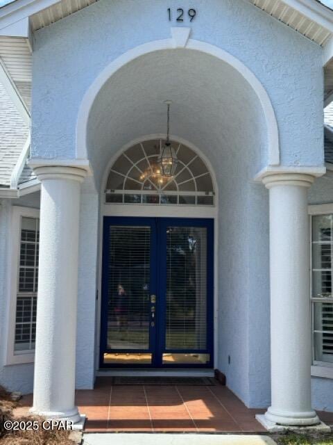 entrance to property featuring french doors and stucco siding