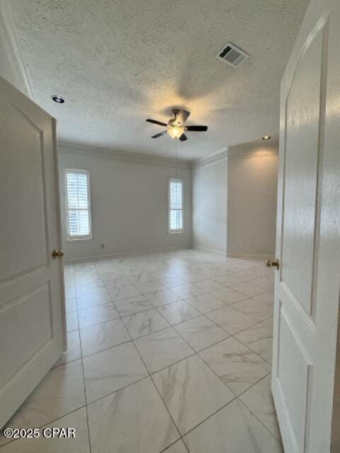 unfurnished room with visible vents, marble finish floor, and ornamental molding