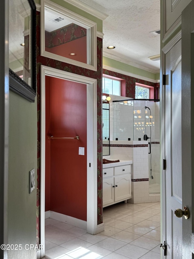 hallway with ornamental molding, light tile patterned floors, visible vents, and a textured ceiling